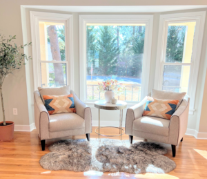 A sunlit living room with two sofas, a coffee table, and a cozy rug